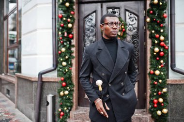 Zarif siyah ceket, holding retro baston baston şişesi veya altın elmas topu saplı tippling kamışı olarak şık Afro-Amerikan beyefendi. Zengin moda afro adama karşı Noel süsleri.