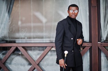 Zarif siyah ceket, holding retro baston baston şişesi veya altın elmas topu saplı tippling kamışı olarak şık Afro-Amerikan beyefendi. Zengin moda afro adam.