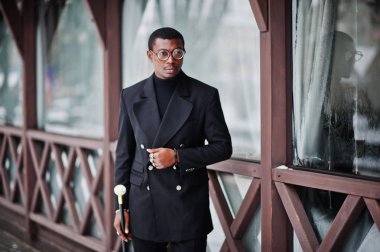Zarif siyah ceket, holding retro baston baston şişesi veya altın elmas topu saplı tippling kamışı olarak şık Afro-Amerikan beyefendi. Zengin moda afro adam.