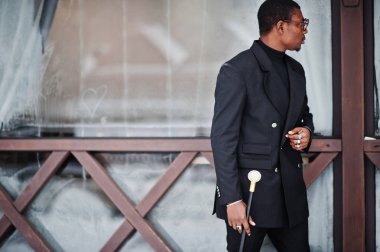 Zarif siyah ceket, holding retro baston baston şişesi veya altın elmas topu saplı tippling kamışı olarak şık Afro-Amerikan beyefendi. Zengin moda afro adam.