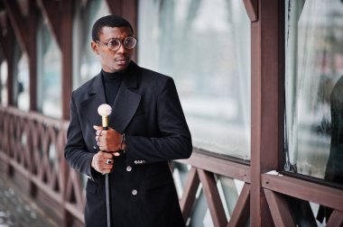 Zarif siyah ceket, holding retro baston baston şişesi veya altın elmas topu saplı tippling kamışı olarak şık Afro-Amerikan beyefendi. Zengin moda afro adam.