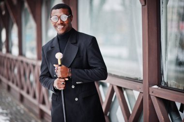 Zarif siyah ceket, holding retro baston baston şişesi veya altın elmas topu saplı tippling kamışı olarak şık Afro-Amerikan beyefendi. Zengin moda afro adam.