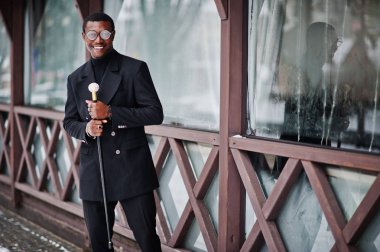 Zarif siyah ceket, holding retro baston baston şişesi veya altın elmas topu saplı tippling kamışı olarak şık Afro-Amerikan beyefendi. Zengin moda afro adam.