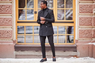 Zarif siyah ceket şık Afro-Amerikan beyefendi. Zengin moda afro adama karşı pencere.