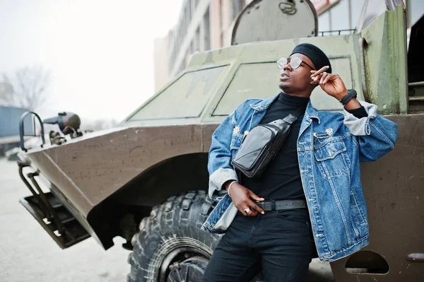 ジーンズのジャケット ベレー帽 アフリカ系アメリカ人 葉巻を吸って Btr 軍事装甲車両に対して提起 — ストック写真