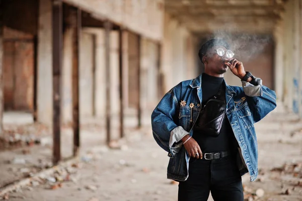 廃工場で葉巻を吸ってジーンズのジャケット ベレー帽 アフリカ系アメリカ人 — ストック写真