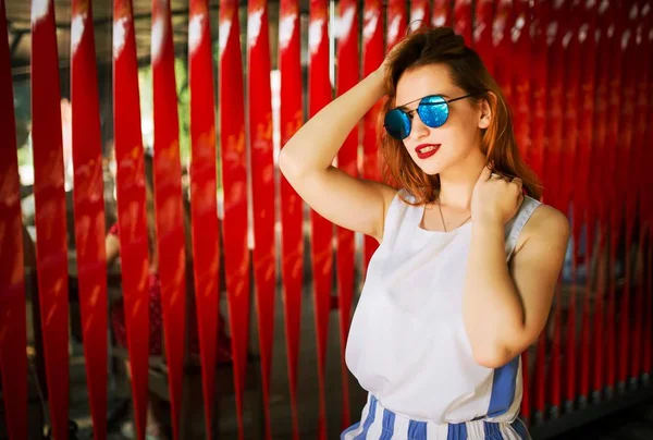 Atractiva Mujer Pelirroja Gafas Sol Posando Sobre Fondo Rojo —  Fotos de Stock