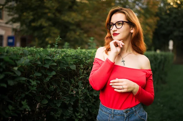 Mulher Ruiva Atraente Óculos Desgaste Blusa Vermelha Saia Jeans Posando — Fotografia de Stock