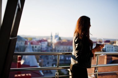 Genç kıvırcık kadının onun şarap bir barda balkon.