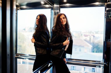 Asansör, deri ceketli genç kıvırcık kadın.