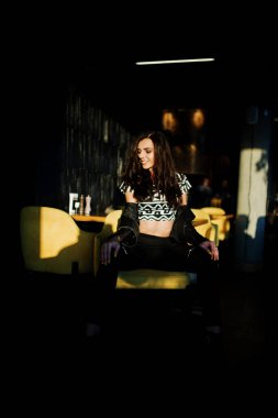 Bir barda deri ceketli genç kıvırcık kadın.