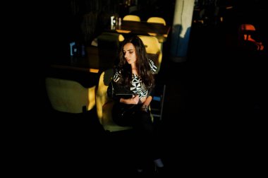 Bir barda deri ceketli genç kıvırcık kadın.