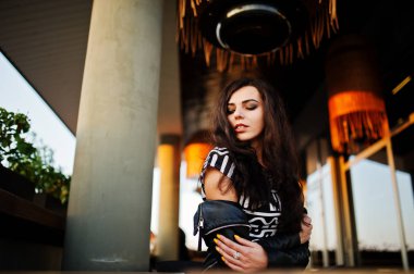 Bir barda deri ceketli genç kıvırcık kadın.