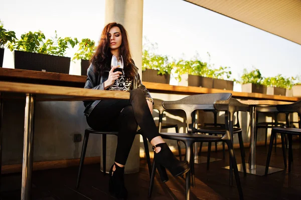 Onun şarap bir barda genç kadının kıvırcık.