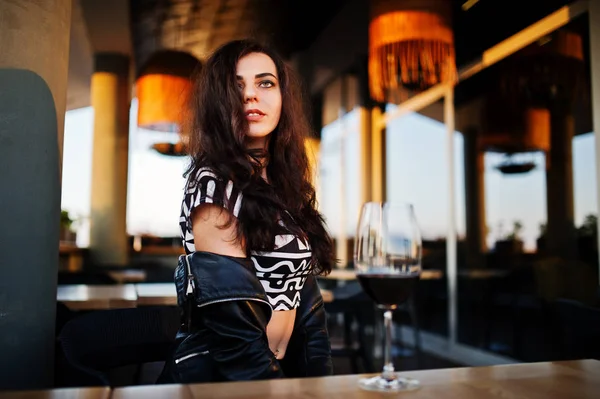 Onun şarap bir barda genç kadının kıvırcık.