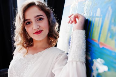 Onu sanat resim yanında beyaz elbiseli Genç ve güzel gilrl ressam.