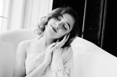 Bath adlı oturan beyaz elbiseli Genç ve güzel kıvırcık gilrl.