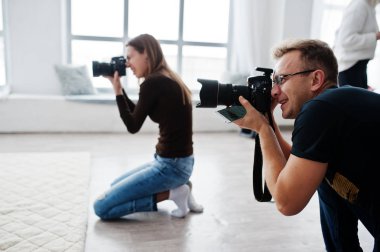 İki fotoğrafçılar stüdyo üzerinde çekim ekibi. İş profesyonel fotoğrafçı.