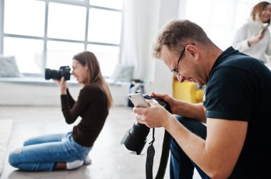 İki fotoğrafçılar stüdyo üzerinde çekim ekibi. İş profesyonel fotoğrafçı.