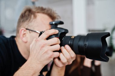 İş yerinde photorapher kadar büyük kamera ve lens ile kapatın. Profesyonel çekim.