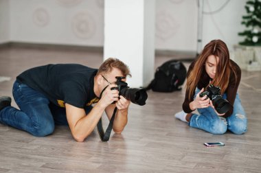 The team of two photographers shooting on studio at knees. Professional photographer on work. Master class. clipart