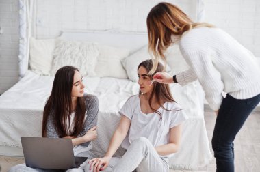 Sanatçı makyaj modelleri studio photoshoot önce laptop ile iki ikiz hazırlamak.