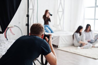 Takımın iki fotoğrafçıların ikizler laptop arayan modelleri kızlar stüdyo çekim. İş profesyonel fotoğrafçı.