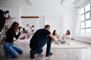 Takımın iki fotoğrafçıların pizza yemek studio ikiz kızlar üzerinde çekim. İş profesyonel fotoğrafçı.