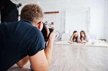 Kim pizza yemek studio ikiz kızlar üzerinde çekim adam fotoğrafçı. İş profesyonel fotoğrafçı.