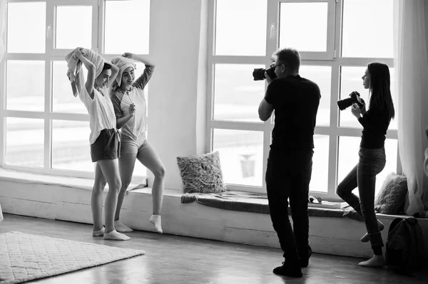 两个摄影师的团队在演播室的大窗户上拍摄双胞胎模特女孩 专业摄影师的工作 — 图库照片
