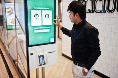 Hintli müşteri mağazasında sipariş ve kendi ödeme kat kiosk ödeme terminal hızlı yemeğe para. Dil seçimi ekranında olun.
