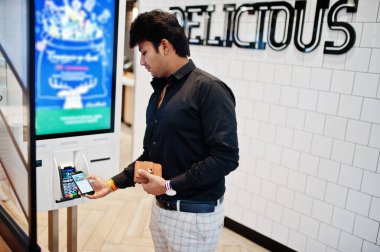 Hintli müşteri mağazasında sipariş ve kendi ödeme kat kiosk aracılığıyla cep telefonu üzerinde temassız kredi kartıyla ödeme terminal hızlı yemeğe para. Pass ödemek.