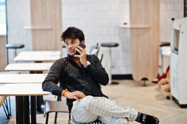 Fast food café'de oturan, cep telefonu konuşma ve onun emir bekliyoruz şık Hintli.