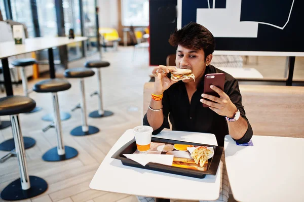 Stylowe Zabawne Indyjski Człowiek Siedząc Kawiarni Fast Food Jedzenie Hamburgerów — Zdjęcie stockowe
