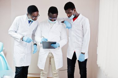 Çalışma, klinik meslektaşları ile tartışırken üç Afro-Amerikan erkek doktor. 