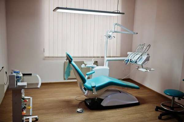 Dental chair by dentists in blue with medic light. Modern dental practice.