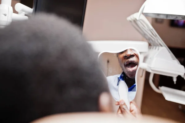 歯科椅子にアフリカ系アメリカ人の患者 歯科医の事務所と医師慣行の概念 ミラーで男を探して歯 — ストック写真
