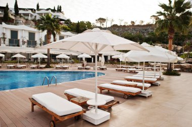 Yüzme Havuzu, güneşlenme yatakları sabah Akdeniz yaz resort otel Türkiye, Bodrum.