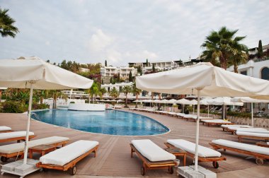 Yüzme Havuzu, güneşlenme yatakları sabah Akdeniz yaz resort otel Türkiye, Bodrum.