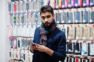 Hint sakallı adam müşteri alıcı arıyorum onun smartphone cep telefonu mağazasında. Güney Asya halkları ve teknolojileri kavramı. Cep Telefonu Dükkanı.