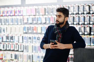 Hint sakallı adam müşteri alıcı arıyorum onun smartphone cep telefonu mağazasında. Güney Asya halkları ve teknolojileri kavramı. Cep Telefonu Dükkanı.