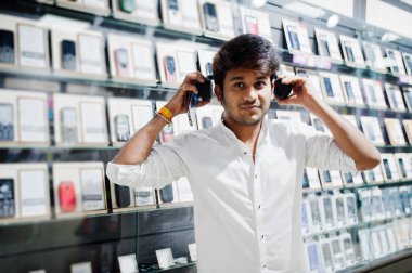 Hintli müşteri alıcı cep telefonu mağaza dinle müzik radyo earphones, onun Smartphone-e doğru bağlamak. Güney Asya halkları ve teknolojileri kavramı. Cep Telefonu Dükkanı.