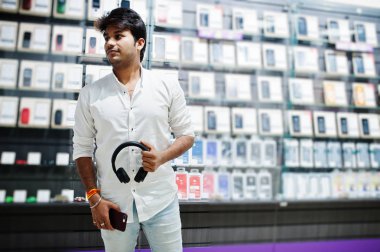 Hintli müşteri alıcı radyo earphones ile cep telefonu mağazasında onun Smartphone-e doğru bağlamak. Güney Asya halkları ve teknolojileri kavramı. Cep Telefonu Dükkanı.
