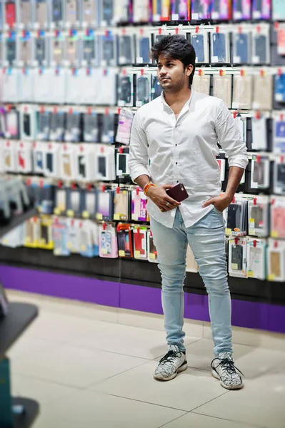 Indian man customer buyer at mobile phone store choose a case for his smartphone. South asian peoples and technologies concept. Cellphone shop.