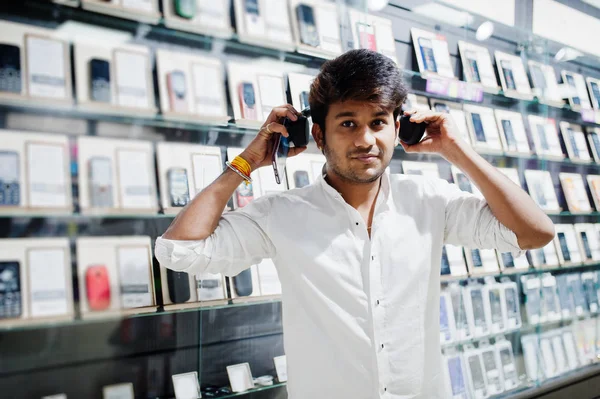 Hintli müşteri alıcı cep telefonu mağaza dinle müzik radyo earphones, onun Smartphone-e doğru bağlamak. Güney Asya halkları ve teknolojileri kavramı. Cep Telefonu Dükkanı.