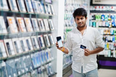 Hintli müşteri alıcı cep telefonu mağazasında onun yeni smartphone ve kredi kartıyla ödeme tercih. Güney Asya halkları ve teknolojileri kavramı. Cep Telefonu Dükkanı.
