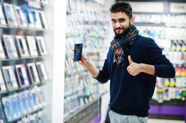 Hint sakallı adam müşteri alıcı cep telefonu mağazasında onun yeni smartphone seçmek ve başparmak sırıtmak. Güney Asya halkları ve teknolojileri kavramı. Cep Telefonu Dükkanı.