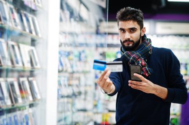 Hint sakallı adam müşteri alıcı cep telefonu mağazasında seçmek onun yeni smartphone ve kredi kartları tutmak. Güney Asya halkları ve teknolojileri kavramı. Cep Telefonu Dükkanı.