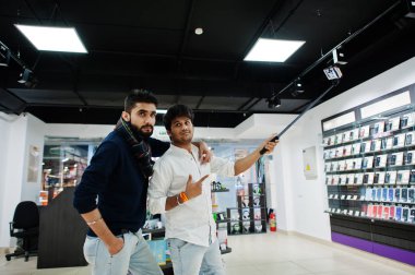 İki Hintliler mans müşteri alıcı, cep telefonu selfie monopod sopa tarafından yapma. Güney Asya halkları ve teknolojileri kavramı. Cep Telefonu Dükkanı.