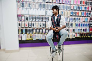Hintli müşteri alıcı cep telefonu Store sandalyede oturuyor. Güney Asya halkları ve teknolojileri kavramı. Cep Telefonu Dükkanı.